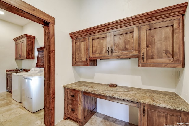 interior space featuring light stone counters, washing machine and dryer, and built in study area