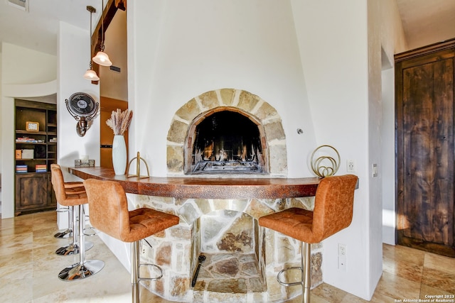 bar with a stone fireplace, visible vents, and bar