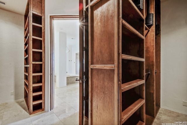 walk in closet with light tile patterned floors