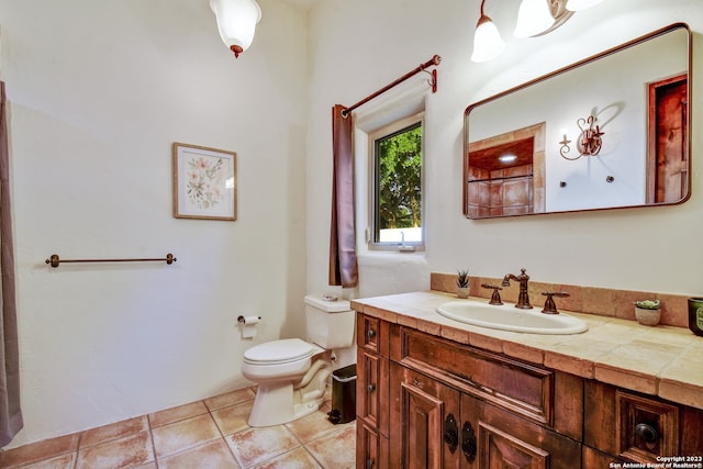 bathroom featuring vanity, tile patterned flooring, and toilet