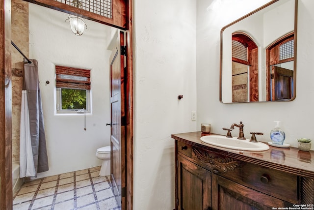 full bath with toilet, vanity, and tile patterned floors