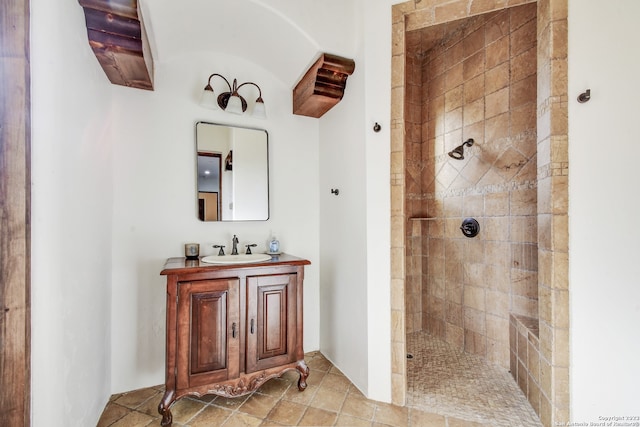 bathroom featuring tiled shower and vanity