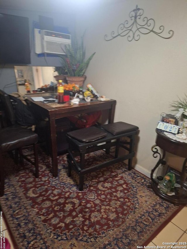 dining area with a wall mounted AC, tile patterned flooring, and baseboards