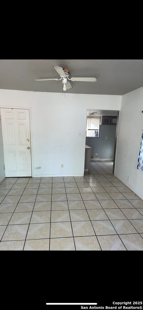 unfurnished room with light tile patterned floors and ceiling fan