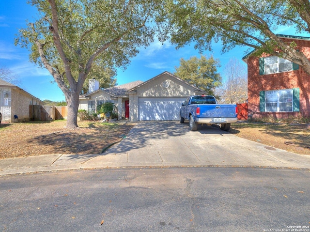 view of front of property with concrete driveway, brick siding, an attached garage, and fence