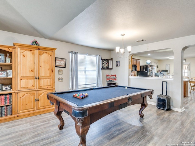 game room featuring visible vents, arched walkways, baseboards, light wood-style flooring, and an inviting chandelier