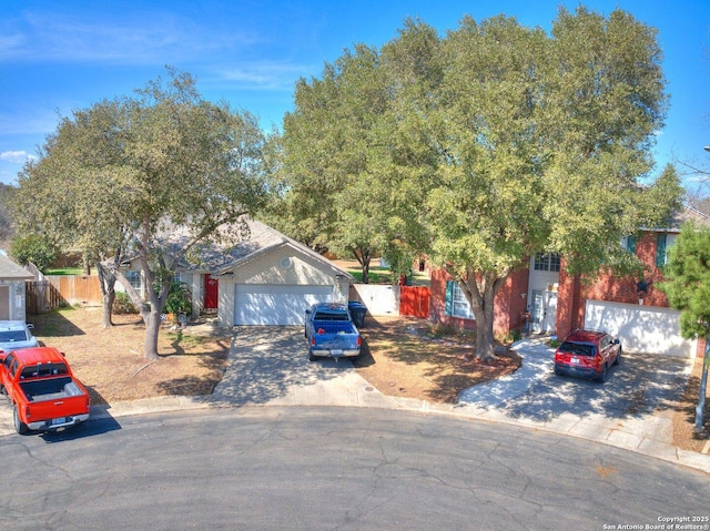 view of front of house with decorative driveway, fence, and an attached garage