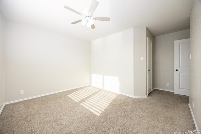 carpeted empty room featuring baseboards and a ceiling fan