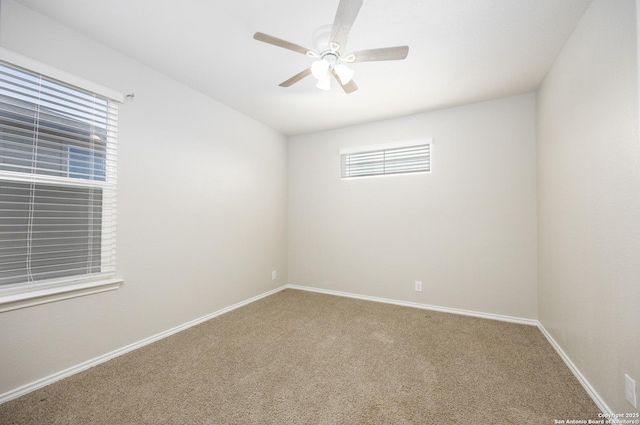 carpeted spare room with baseboards and a ceiling fan