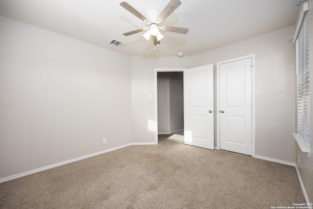 unfurnished bedroom with carpet floors, visible vents, and baseboards