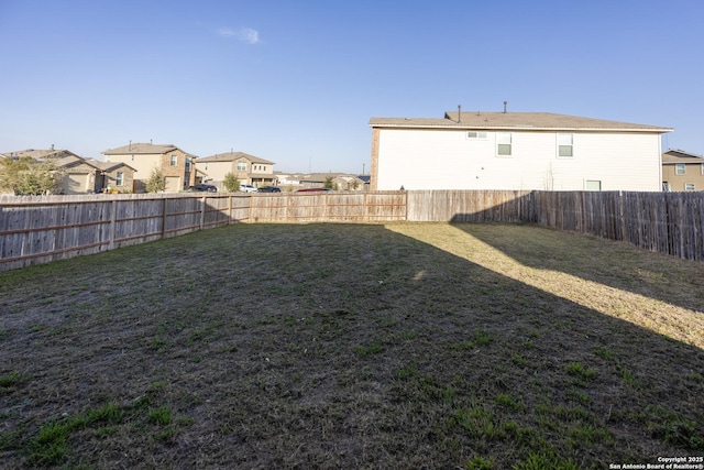 view of yard with a fenced backyard and a residential view