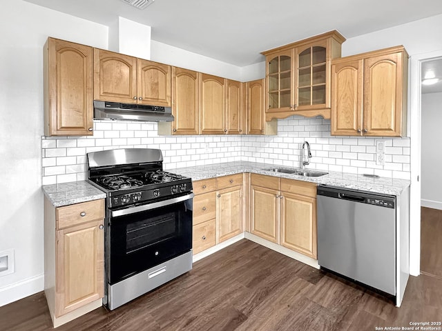 kitchen featuring dark wood-style flooring, stainless steel appliances, glass insert cabinets, a sink, and under cabinet range hood