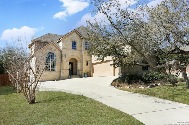 french country style house featuring concrete driveway, a front yard, fence, a garage, and stone siding