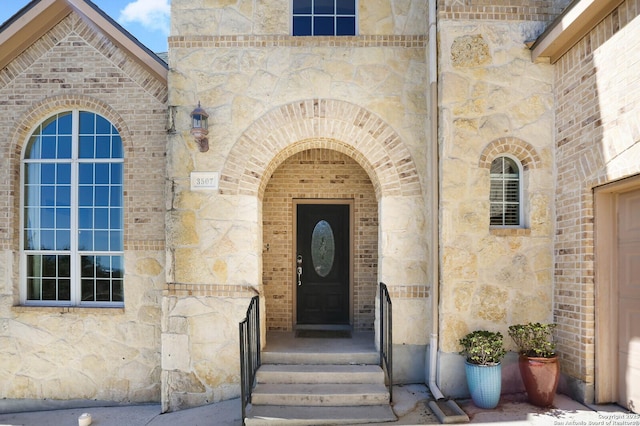 doorway to property with stone siding and brick siding