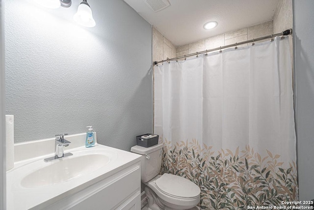 full bath with a textured wall, toilet, vanity, visible vents, and a shower with curtain