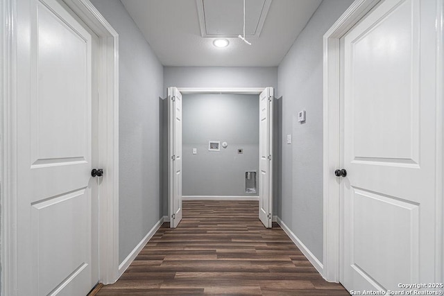 corridor with attic access, baseboards, and dark wood-type flooring