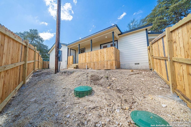 rear view of property with crawl space and a fenced backyard