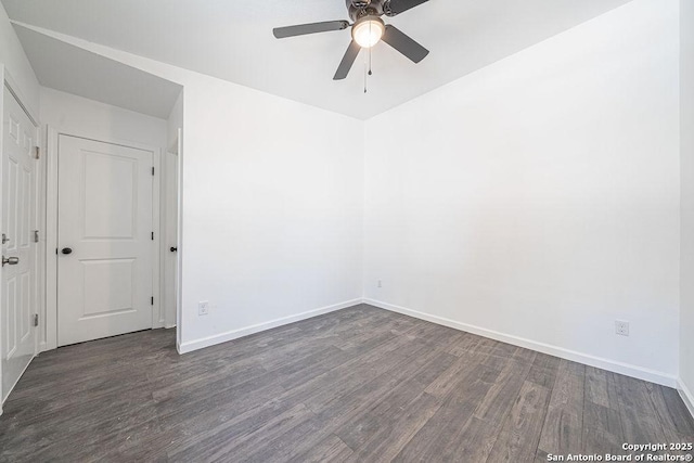 spare room featuring wood finished floors, a ceiling fan, and baseboards