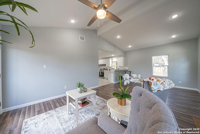 living area with baseboards, visible vents, and wood finished floors