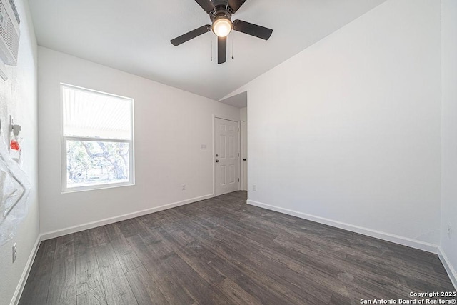 spare room featuring dark wood-style floors, ceiling fan, and baseboards