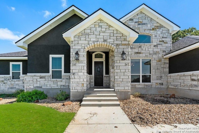 french country style house with stone siding