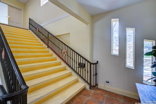 stairway featuring tile patterned floors and baseboards