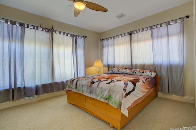 carpeted bedroom with visible vents and ceiling fan