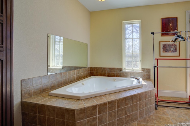 bathroom with tile patterned floors, plenty of natural light, and a tub with jets