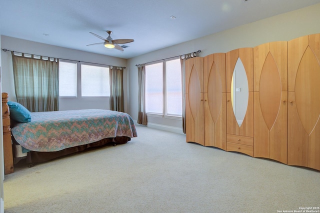 bedroom featuring ceiling fan, baseboards, and light carpet