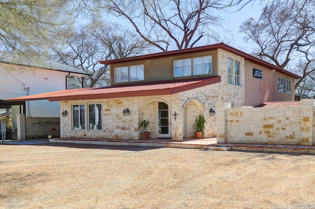 view of front of property with fence and stone siding