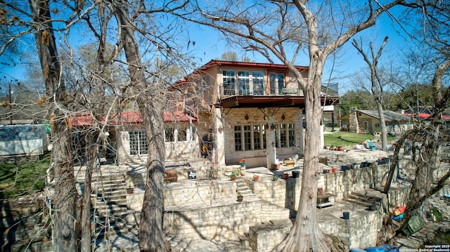 back of house featuring a patio and a balcony