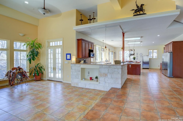 kitchen with light tile patterned floors, appliances with stainless steel finishes, a peninsula, and french doors