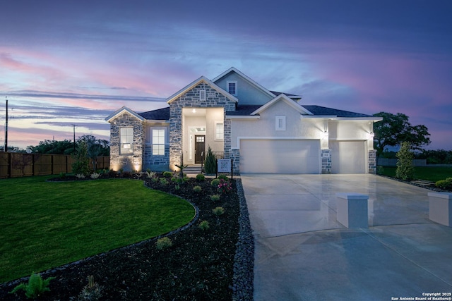 view of front facade with stone siding, a yard, concrete driveway, and fence