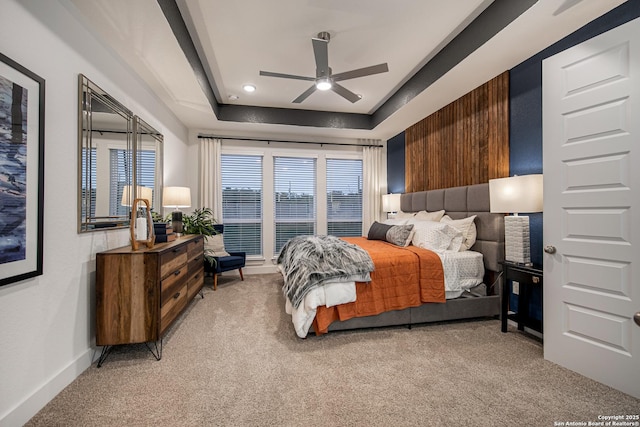 bedroom featuring a tray ceiling, light colored carpet, baseboards, and recessed lighting