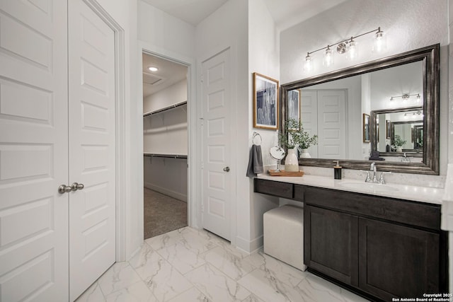 full bath with baseboards, marble finish floor, a spacious closet, vanity, and recessed lighting