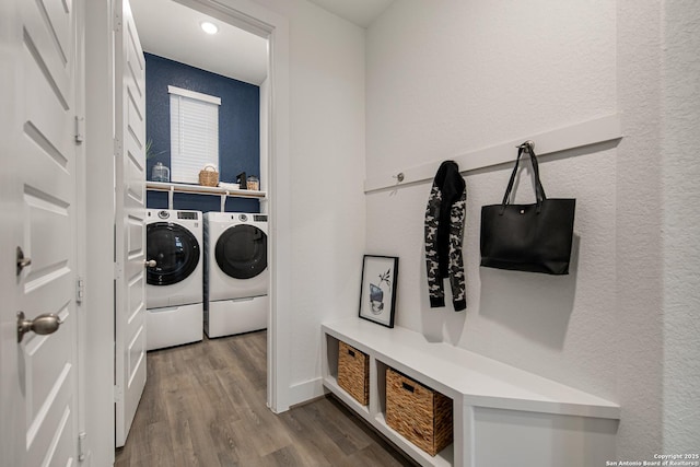 clothes washing area featuring laundry area, washer and clothes dryer, and wood finished floors