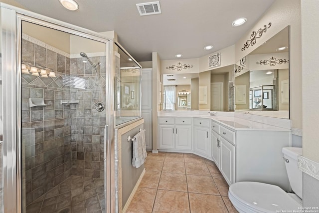 bathroom featuring a stall shower, visible vents, toilet, tile patterned flooring, and vanity