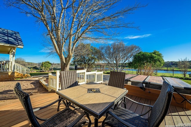 deck featuring outdoor dining space and a water view