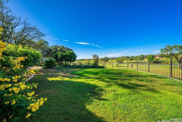 view of yard with a rural view and fence