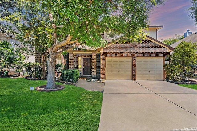 view of front of property with concrete driveway, brick siding, a lawn, and an attached garage