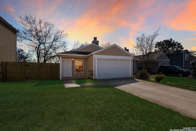 ranch-style home featuring an attached garage, fence, driveway, stucco siding, and a front yard