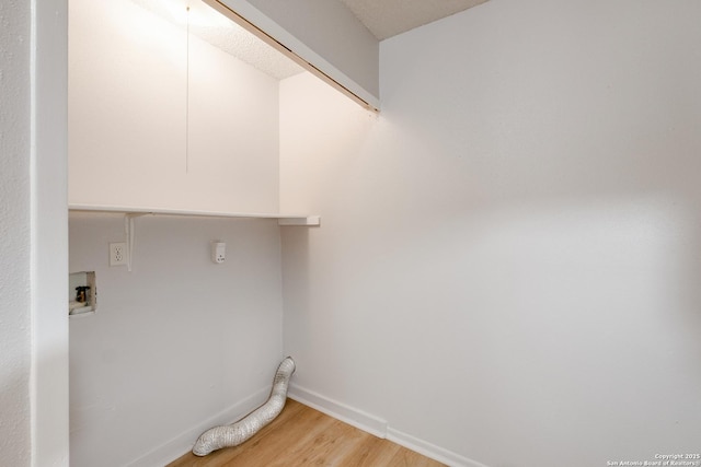 washroom featuring light wood-type flooring, laundry area, hookup for a washing machine, and baseboards