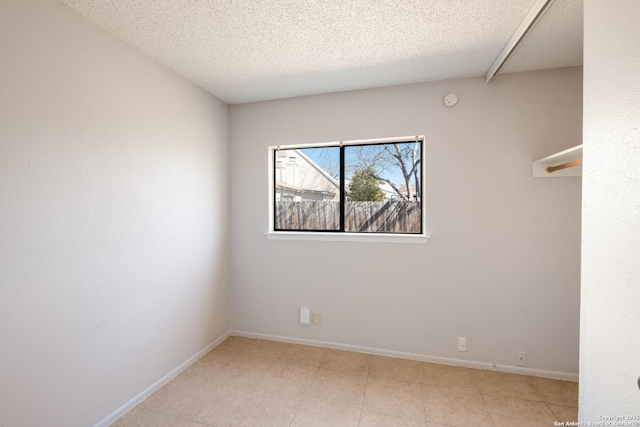 empty room with baseboards and a textured ceiling