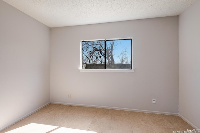 empty room with baseboards and a textured ceiling