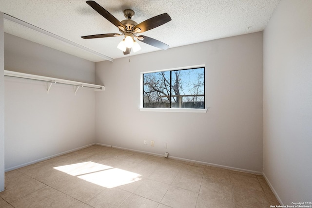 unfurnished bedroom featuring a ceiling fan, a textured ceiling, and baseboards