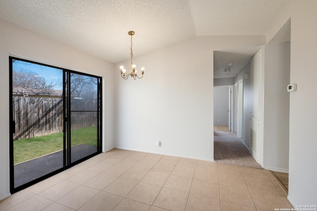 empty room with lofted ceiling, a notable chandelier, a textured ceiling, and light tile patterned floors