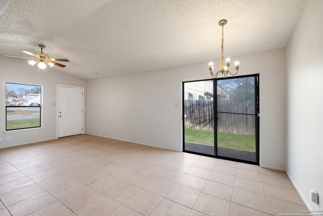 unfurnished room with lofted ceiling, light tile patterned floors, a textured ceiling, and ceiling fan with notable chandelier