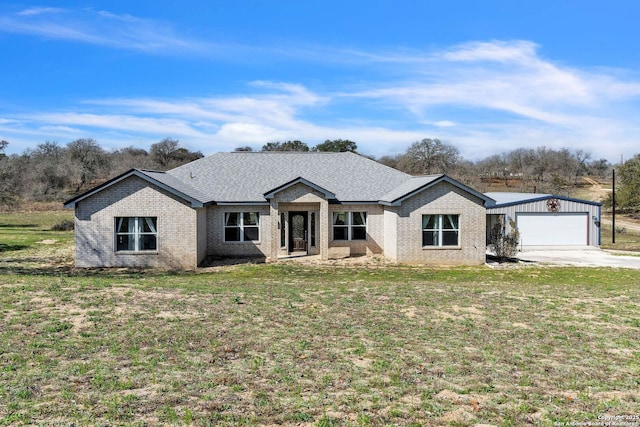 view of front of property featuring an attached garage, a front lawn, a shingled roof, and brick siding