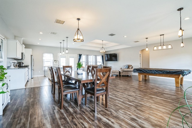 dining space with dark wood-style floors, recessed lighting, a raised ceiling, and visible vents