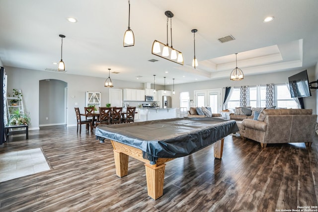 recreation room with billiards, arched walkways, dark wood finished floors, a tray ceiling, and recessed lighting